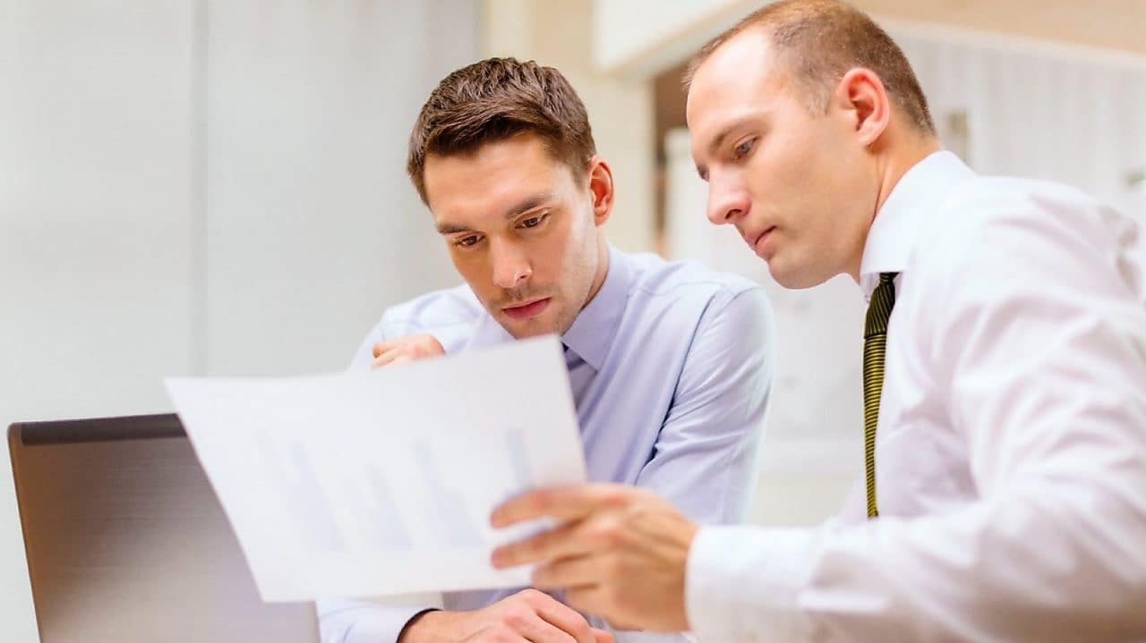 panové studující dokumenty