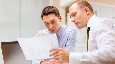 panové studující dokumenty