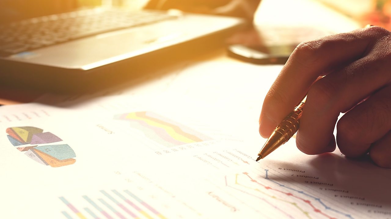 Hand holding pen and writing over graph paper