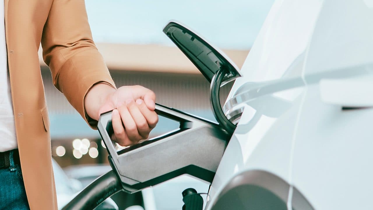 Foto ruky, ktorá drží nabíjací kábel