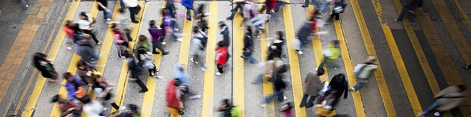 Ľudia prechádzajúci cez rušnú cestu v&nbsp;Hongkongu