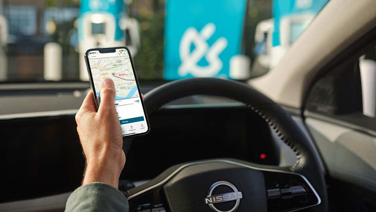 Muž v aute práve zaparkoval pri dobíjacej stanici Shell Recharge