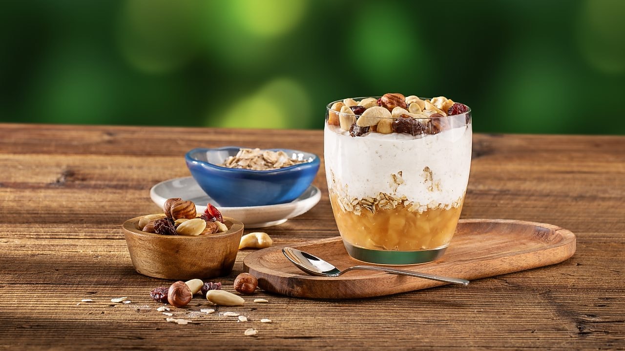 Foto ovsenej kaše v sklenenom pohári s jablkom a orechmi