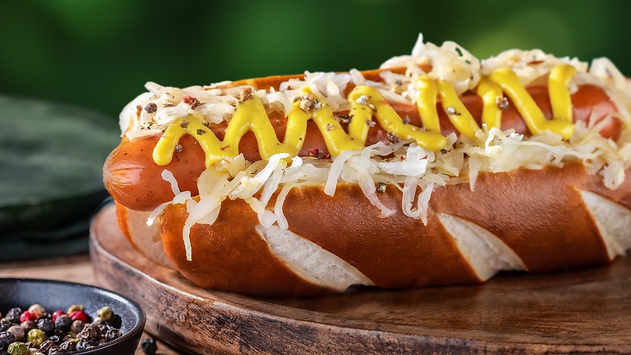 Foto gazdovskeho hot dogu s nivou, kyslou kapustou a horčicou