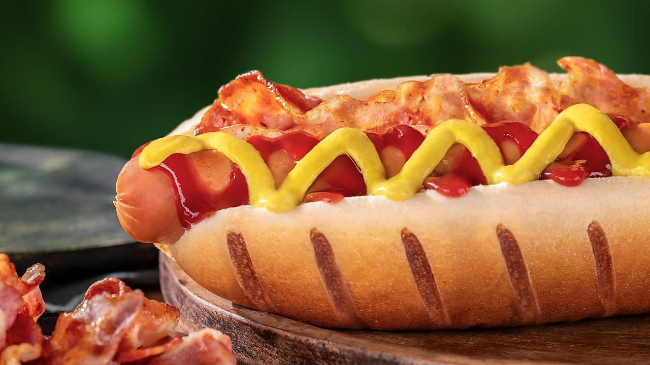 Foto hot dogu Amerika s párkom, so slaninou, horčicou a kečupom