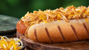 Foto hot dogu Francúzsko s párkom, syrom a karamelizovanou cibuľkou