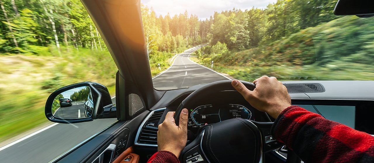Auto prechádza krajinou, pohľad na krajinu z miesta vodiča cez čelné sklo.