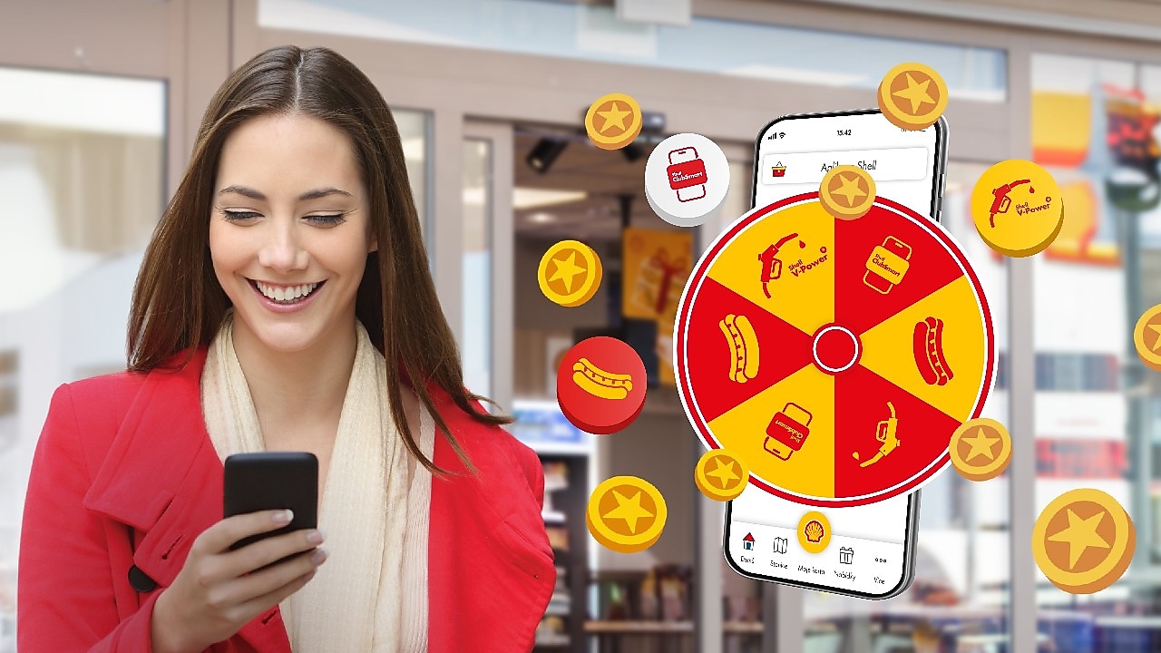 Zákazníčka s telefónom sa teší pri kolese šťastia